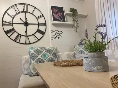 a room with a table and a large clock on the wall at Villa Árbol del Tule in Chiclana de la Frontera