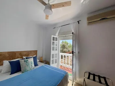 a bedroom with a blue bed and a balcony at Villa Mar in Chiclana de la Frontera