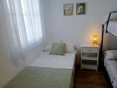 a small bedroom with a bed and a night stand at Villa Mar in Chiclana de la Frontera