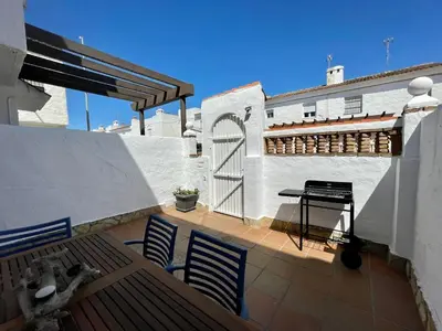 a balcony with chairs and a grill on a building at Villa Mar in Chiclana de la Frontera