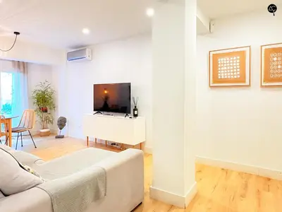 a living room with a couch and a tv at El Encanto de la Playa Santa Mª Grupo AC Gestion in Cádiz