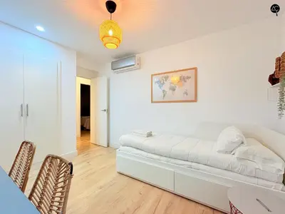 a white living room with a couch and a table at El Encanto de la Playa Santa Mª Grupo AC Gestion in Cádiz