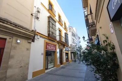 an empty street in an alley between buildings at Apartamentos Santa María 15 in Jerez de la Frontera