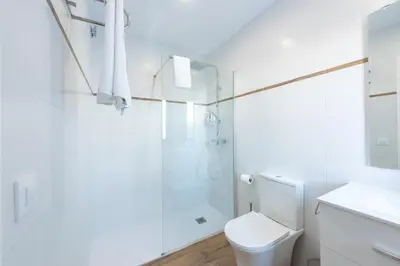 a white bathroom with a shower and a toilet at Apartamentos Santa María 15 in Jerez de la Frontera