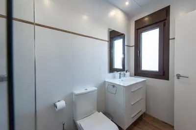 a white bathroom with a toilet and a sink at Apartamentos Santa María 15 in Jerez de la Frontera