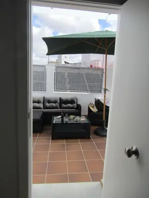 a living room with a couch and an umbrella at Apartamentos Santa María 15 in Jerez de la Frontera