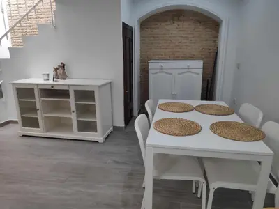 a white dining room with a table and chairs at Sonsoles Apartamentos Bahía Sur in San Fernando
