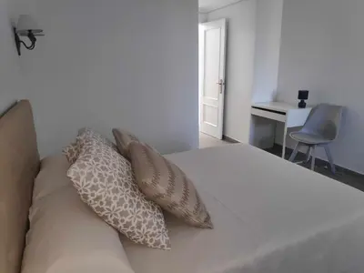 a bedroom with a bed with pillows and a desk at Sonsoles Apartamentos Bahía Sur in San Fernando