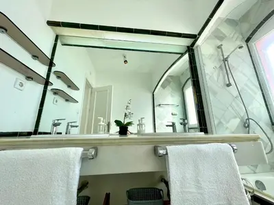 a bathroom with a large mirror and white towels at GATU Villa Océano frente al mar en Puerto Sherry 