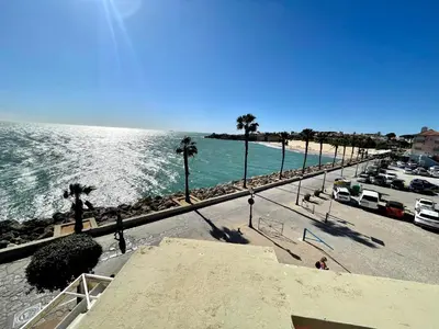 a view of a beach with palm trees and the ocean at GATU Villa Océano frente al mar en Puerto Sherry 