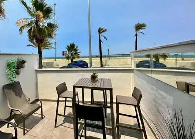 a table and chairs on a balcony with a view of the beach at Arenas de Sanlúcar II in Sanlúcar de Barrameda
