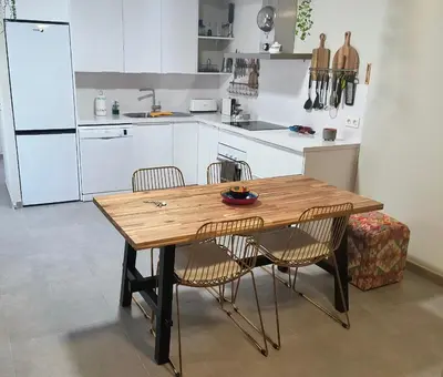 a kitchen with a wooden table and two chairs at Arenas de Sanlúcar II in Sanlúcar de Barrameda