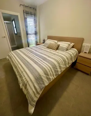 a bedroom with a large bed with striped sheets and pillows at Arenas de Sanlúcar II in Sanlúcar de Barrameda