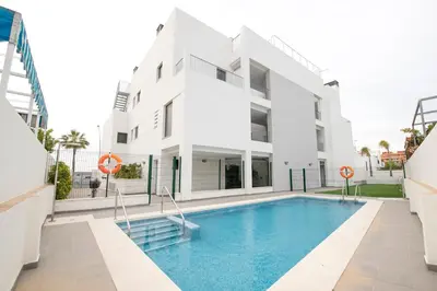 a building with a swimming pool in front of a building at Arenas de Sanlúcar II in Sanlúcar de Barrameda