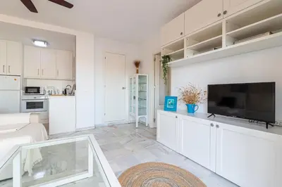 a living room with white cabinets and a flat screen tv at Top Ático Estudio Sur - Terraza in Jerez de la Frontera