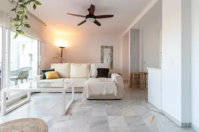 a living room with a white couch and a ceiling fan at Top Ático Estudio Sur - Terraza in Jerez de la Frontera