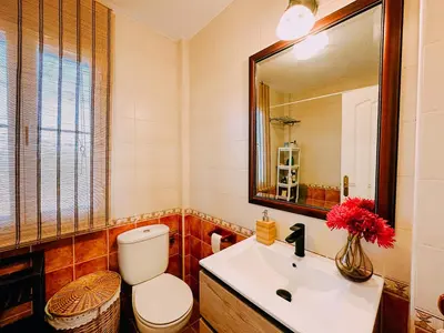a bathroom with a toilet and a sink and a mirror at Mika's House Pool in Sanlúcar de Barrameda