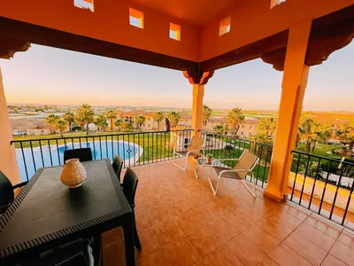 a balcony with a table and chairs and a view at Mika's House Pool in Sanlúcar de Barrameda