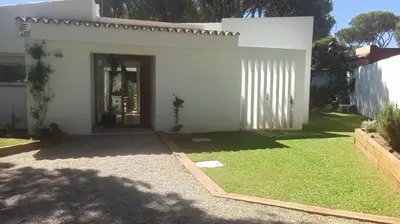 a white house with a lawn in front of it at Diseño y luz entre los pinos in Chiclana de la Frontera