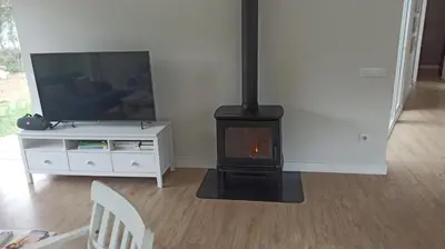 a living room with a fireplace and a television at Diseño y luz entre los pinos in Chiclana de la Frontera