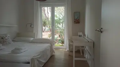 a bedroom with a bed and a desk and a window at Diseño y luz entre los pinos in Chiclana de la Frontera