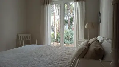 a bedroom with a bed and a large window at Diseño y luz entre los pinos in Chiclana de la Frontera