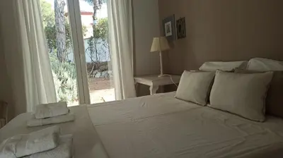 a white bed in a bedroom with a window at Diseño y luz entre los pinos in Chiclana de la Frontera