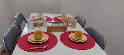 a table with red plates and yellow cups on it at La Playita Santa María Beach in Cádiz