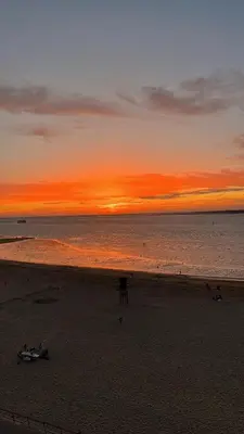 a sunset on the beach with a boat on the beach at Mirador de Sanlucar 9 in Sanlúcar de Barrameda