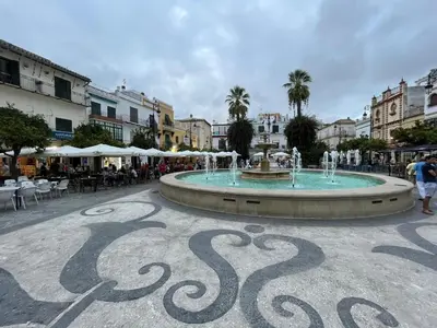 a fountain in the middle of a street with buildings at Mirador de Sanlucar 9 in Sanlúcar de Barrameda