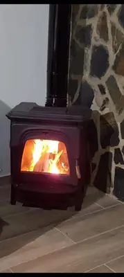 a black stove with a fire in it at Casa La Cabaña - Solo Familias in Chiclana de la Frontera