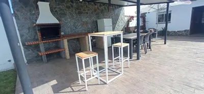a row of bar stools in front of a fireplace at Casa La Cabaña - Solo Familias in Chiclana de la Frontera
