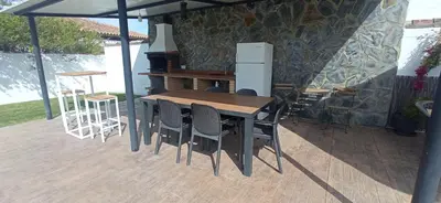 a wooden table and chairs on a patio at Casa La Cabaña - Solo Familias in Chiclana de la Frontera