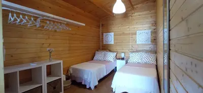 a bedroom with two beds in a wooden cabin at Casa La Cabaña - Solo Familias in Chiclana de la Frontera