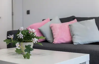 a living room with a couch with pink and grey pillows at New York Style Luxury 3 dormitorios in Jerez de la Frontera