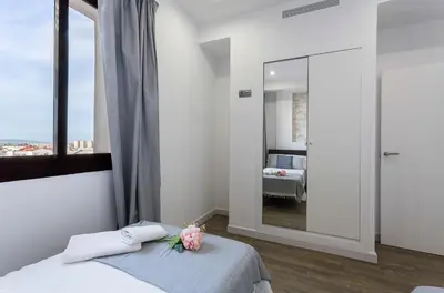 a bedroom with a mirror and a bed with flowers on it at New York Style Luxury 3 dormitorios in Jerez de la Frontera