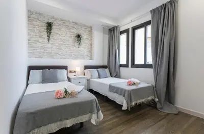 a bedroom with two beds and two windows at New York Style Luxury 3 dormitorios in Jerez de la Frontera