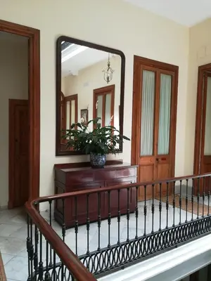 a mirror on the wall in a room with a staircase at Nuevo Hotel in Jerez de la Frontera