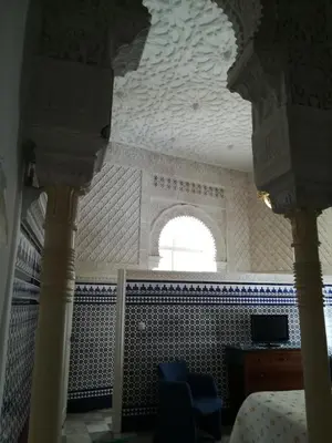 a room with a ceiling with a window and blue chairs at Nuevo Hotel in Jerez de la Frontera