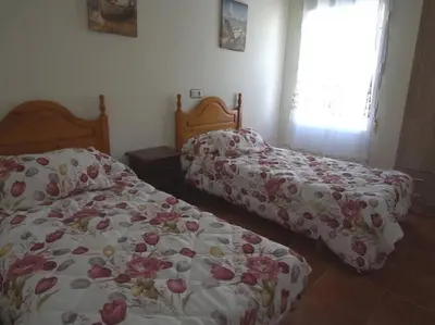two beds sitting next to each other in a bedroom at Casa Rural Dehesa de Algar in Algar