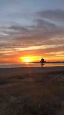 a sunset on the beach with the sun setting at VILLA ANDEMAR in Chiclana de la Frontera