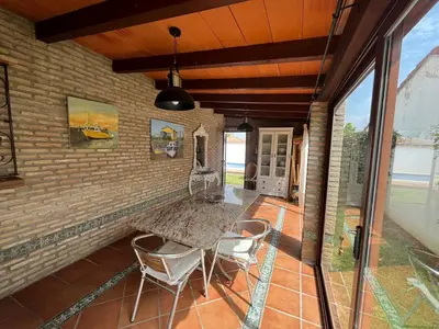a patio with two chairs and a brick wall at VILLA ANDEMAR in Chiclana de la Frontera