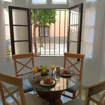 a dining room table with food and drinks and a window at Jerez Palace House in Jerez de la Frontera
