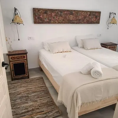 a bedroom with two beds and a table and a mirror at Jerez Palace House in Jerez de la Frontera