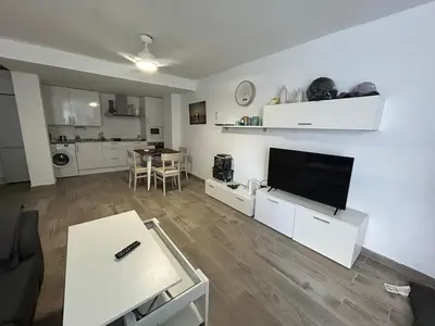 a living room with a flat screen tv on a white wall at Apartamento Empul La Barrosa in Chiclana de la Frontera