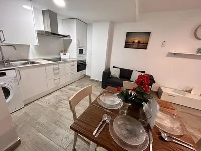 a kitchen and living room with a dining table and a kitchen at Apartamento Empul La Barrosa in Chiclana de la Frontera