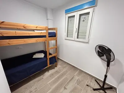 a room with two bunk beds and a window at Apartamento Empul La Barrosa in Chiclana de la Frontera