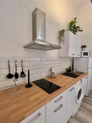 a kitchen with white cabinets and a wooden counter top at La Parra Apartamento in Jerez de la Frontera