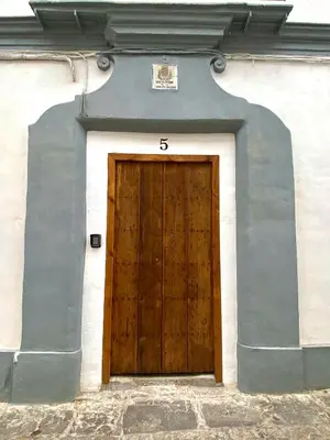 a wooden door with the number on the side of a building at La Parra Apartamento in Jerez de la Frontera