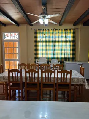 a dining room with a table and chairs and a ceiling fan at VILLA LA MOMITA in Chiclana de la Frontera